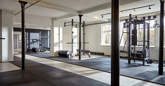 Moderne revalidatieruimte met trainingsrekken en gewichten